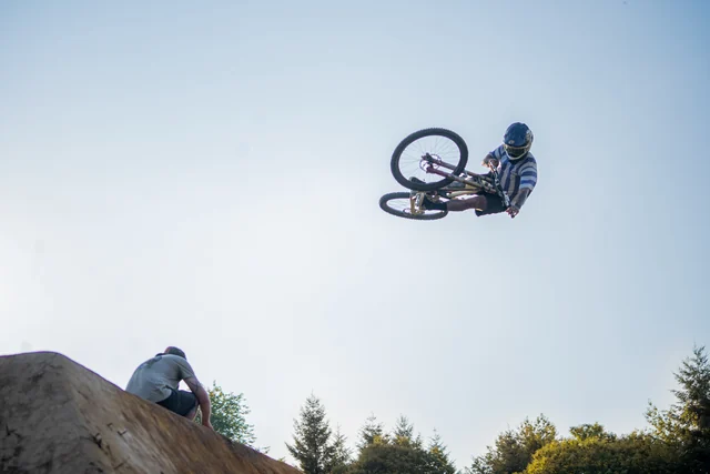 A rider turning a bike sideways above a dirt jump at Backyard Battle