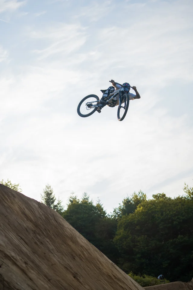 A rider and bike high above a dirt jump at Backyard Battle