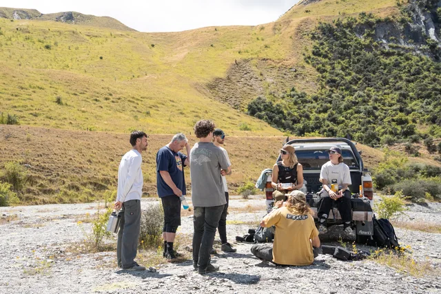 Riders gathered around a pickup in the mountains