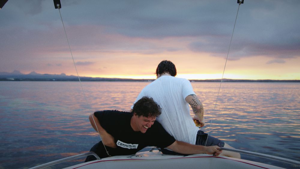 Two friends on the bow of a small boat at dawn