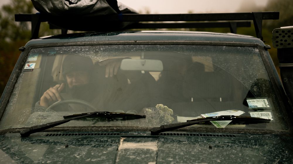 Two friends in the truck seen through the dusty windscreen